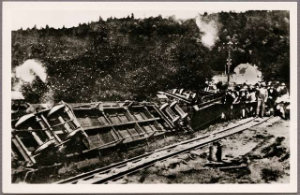 Narrow Gauge train dereailment - carriges and locomotove can be seen on thier sides with a crowd, dressed in 19th century cloathing, overlooking the scene
